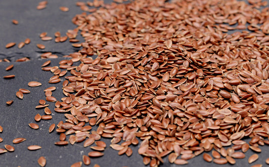 High-resolution close-up of nutritious flaxseeds scattered on a dark background, perfect for health and diet concepts.